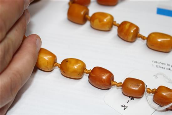 A single strand barrel shaped amber bead necklace, 86cm.